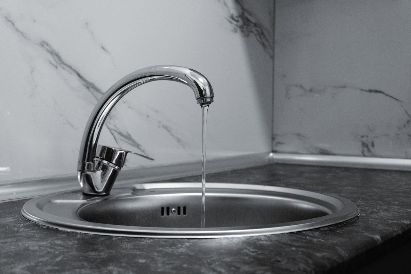 Moderner Wasserhahn mit fließendem Wasser in einer Küche