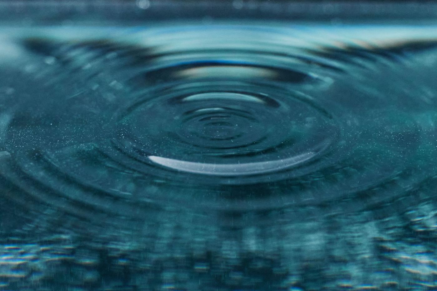 Nahaufnahme einer Wasserwelle auf blauer Wasseroberfläche